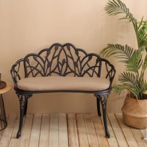Black floral cast aluminum garden bench with included cushion in styled setting